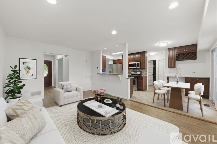 A modern living room with a white sofa and a coffee table in the center.