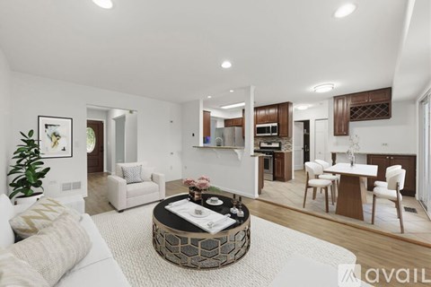 A modern living room with a white sofa and a coffee table in the center.