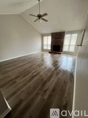 A room with wooden floors and a ceiling fan.