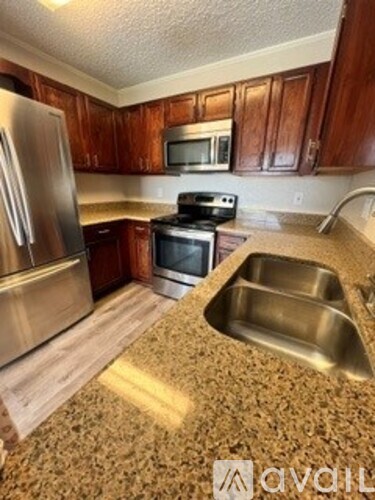 A kitchen with a stainless steel refrigerator, microwave, oven, and sink.