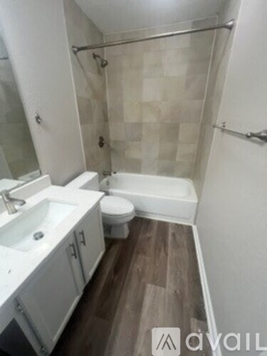 A bathroom with a toilet, sink, and shower.
