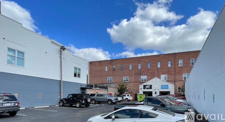 A parking lot with cars and a building in the background.