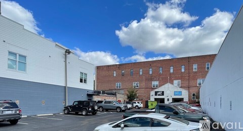 A parking lot with cars and a building in the background.