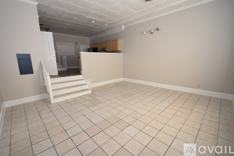 A room with a white tiled floor and a white chair.