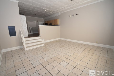 A room with a white tiled floor and a white chair.