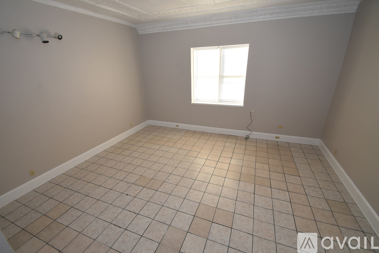 A room with a tiled floor and a window letting in natural light.