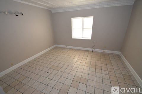 A room with a tiled floor and a window letting in natural light.