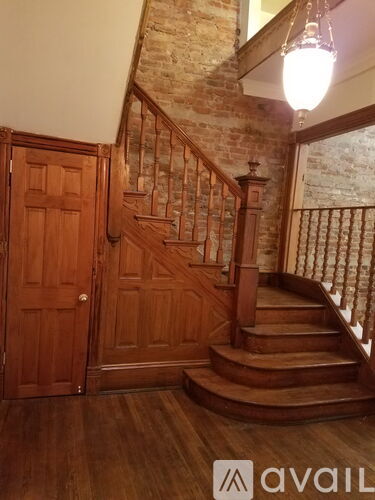 A wooden staircase with a metal railing and a wooden door.