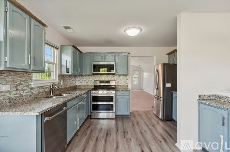 A kitchen with blue cabinets and stainless steel appliances.