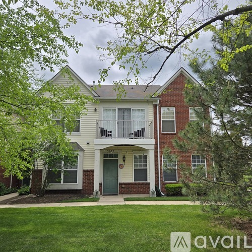 A two-story house with a balcony on the second floor.