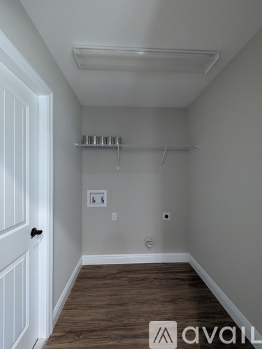 A room with a white door and a wooden floor.