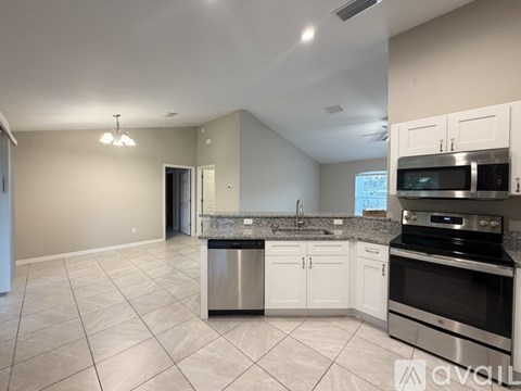A kitchen with white cabinets and a granite countertop.