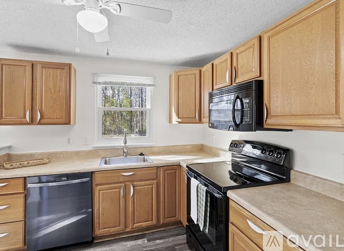 A kitchen with wooden cabinets and a black stove top oven.