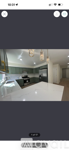 A modern kitchen with a white countertop and a stainless steel refrigerator.