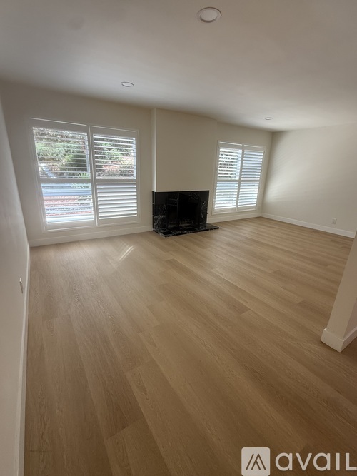 A living room with a fireplace and wooden flooring.