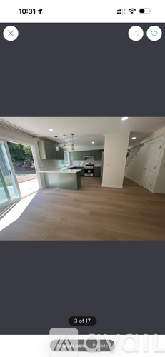 A room with wooden flooring and a large window.