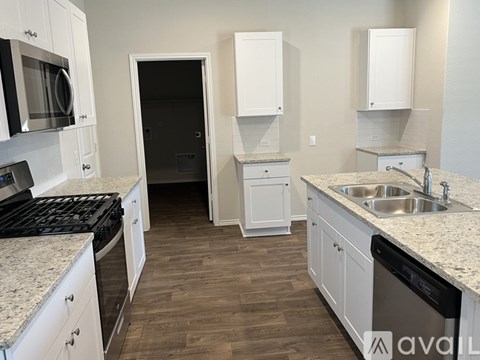 A kitchen with white cabinets and a black stove top oven.