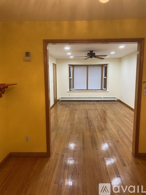 A room with wooden floors and a ceiling fan.