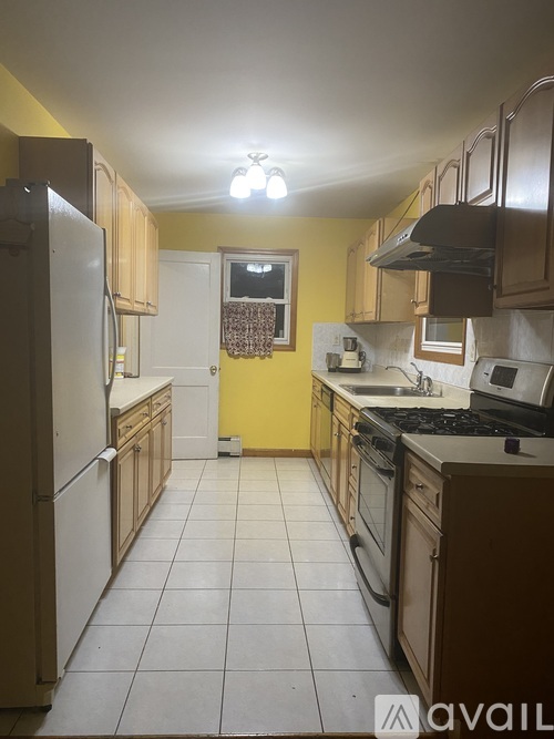 A kitchen with yellow walls and white appliances.