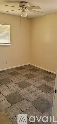 A room with a ceiling fan and a tiled floor.