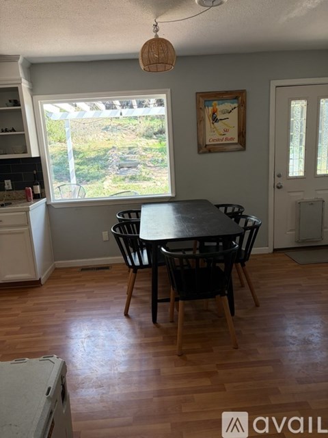 A dining room with a table and chairs.