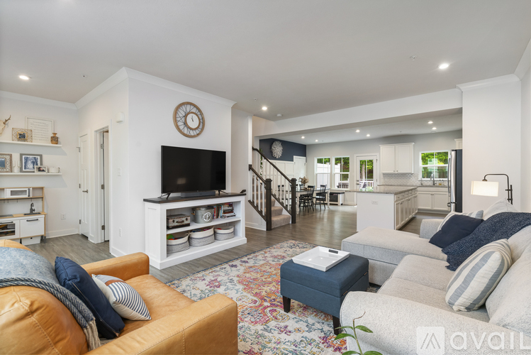A living room with a brown leather couch and a white entertainment center.
