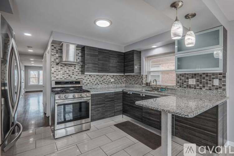 A modern kitchen with a stainless steel oven and a marble countertop.