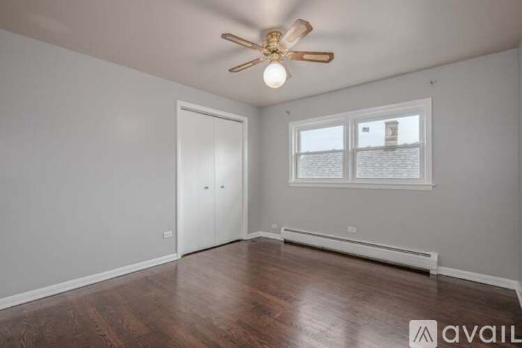 A room with a ceiling fan and a window.