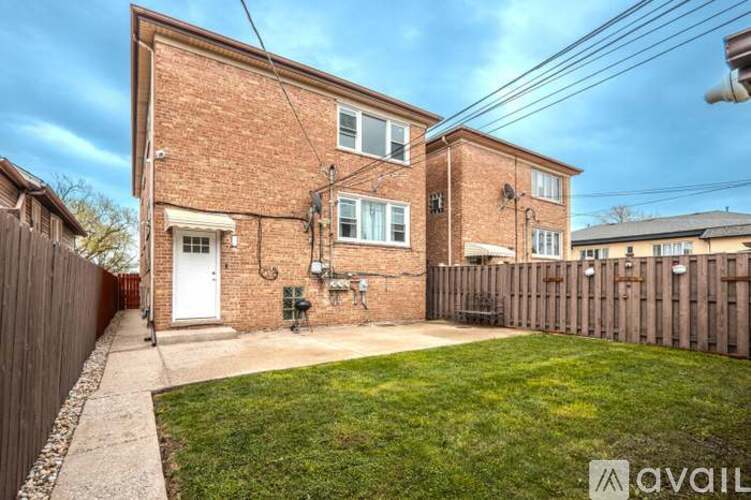 A brick house with a white door and a small garden.