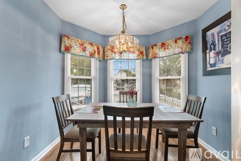 A dining room with a table set for four.