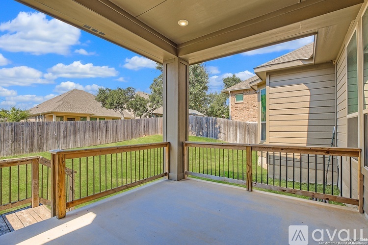 A patio with a wooden fence and a metal railing.