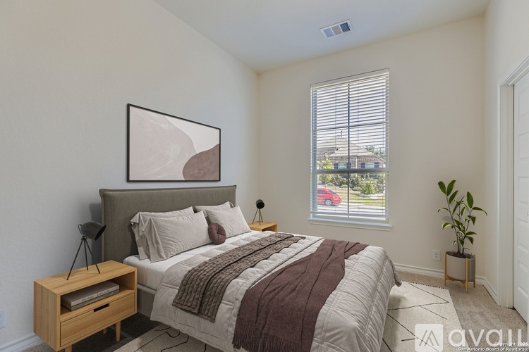 A bedroom with a large bed and a window overlooking a street.