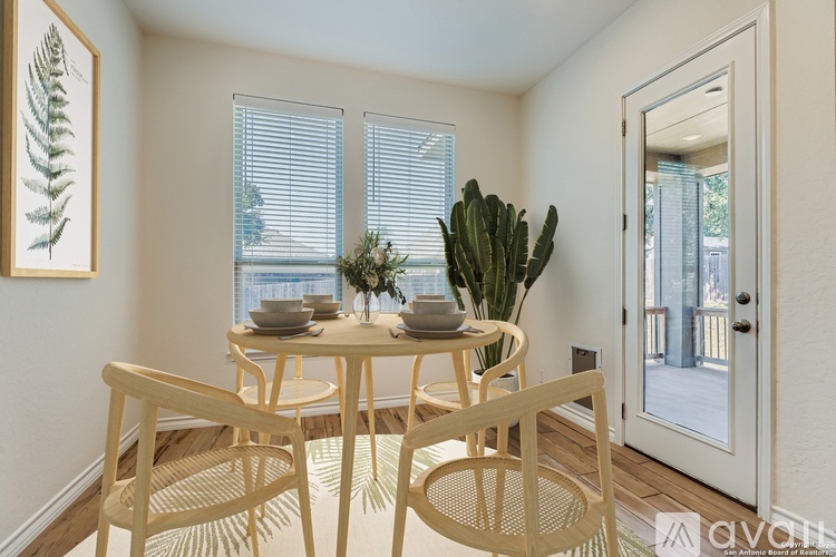 A dining room with a table set for two and a cactus in the corner.