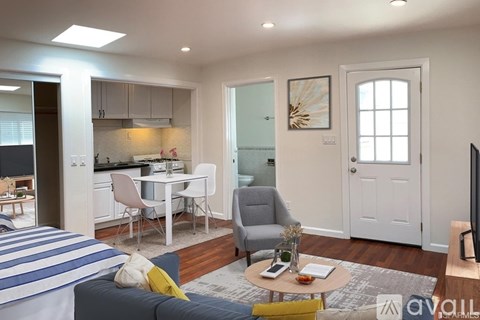 A living room with a striped sofa and a dining table with chairs.