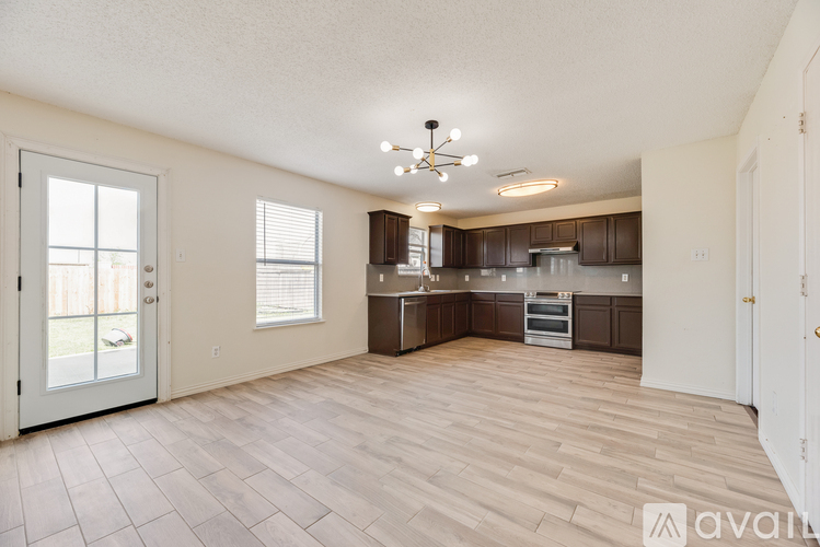 A spacious kitchen with wooden flooring and a central island.