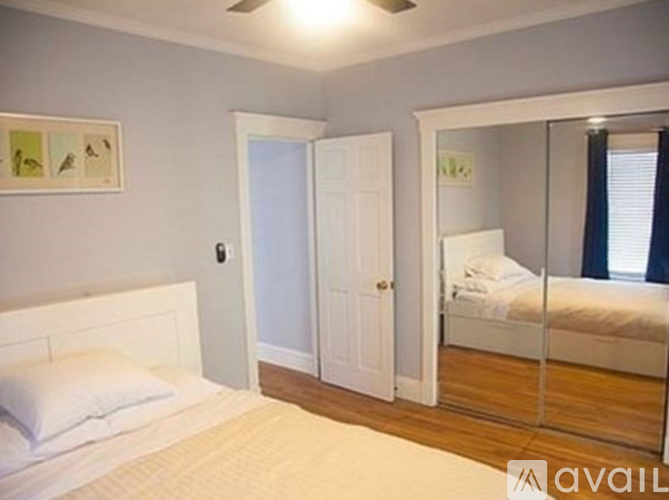 A bedroom with a bed, a mirror, and a door.