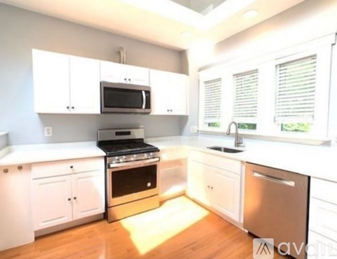 A kitchen with white cabinets and a stainless steel dishwasher.