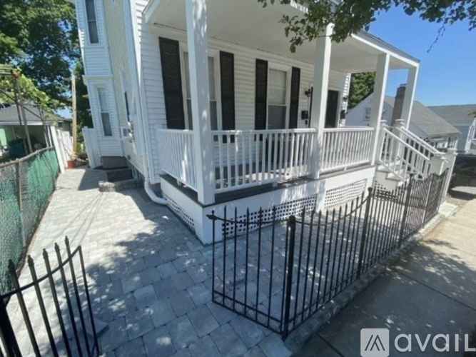 A white house with a black fence in front.