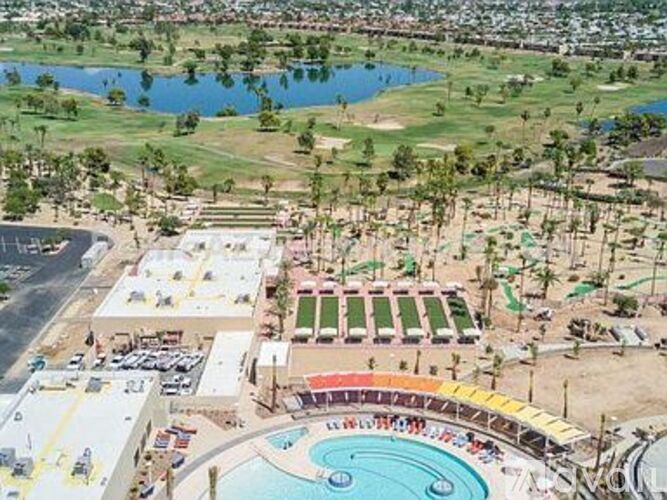 A large outdoor swimming pool with a diving board and a slide.