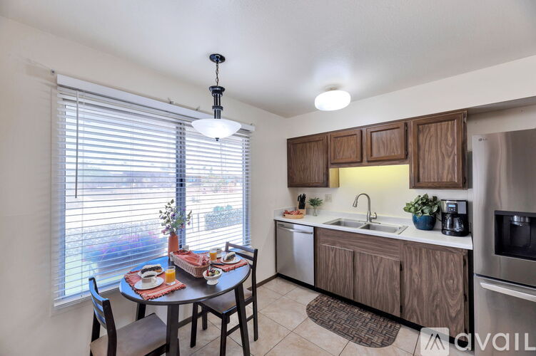 A kitchen with a table and chairs by a window.
