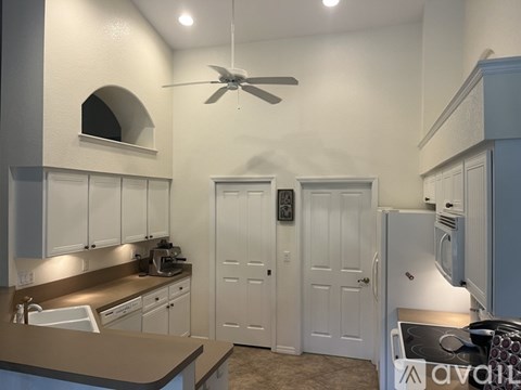 A kitchen with white cabinets and a brown countertop.