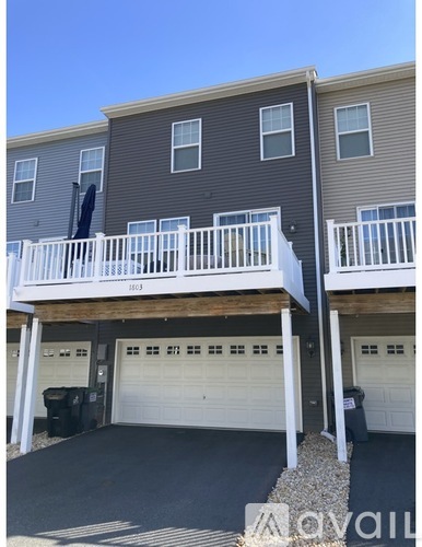 A two-story building with a balcony and a garage.