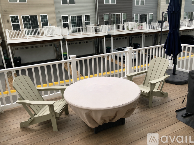 A hot tub is surrounded by two chairs on a deck.