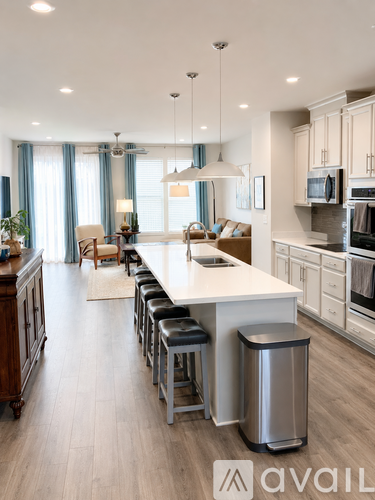 A modern kitchen with a long island and stools.