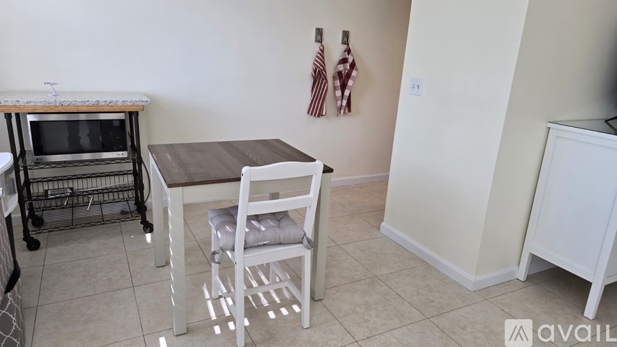 A kitchen area with a table, chairs, and a microwave.