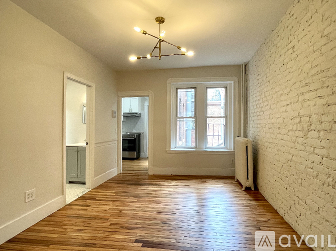 A room with wooden floors and a white brick wall.