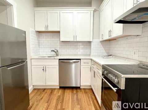 A kitchen with white cabinets and a stainless steel dishwasher.