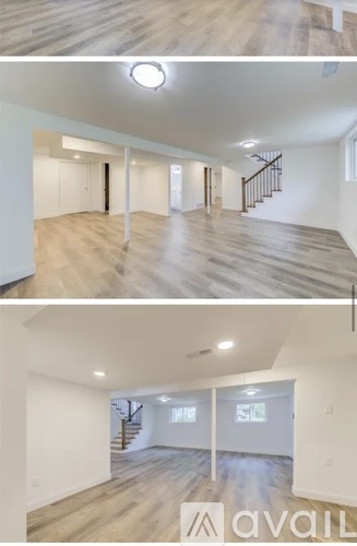 A spacious room with wooden floors and a staircase.