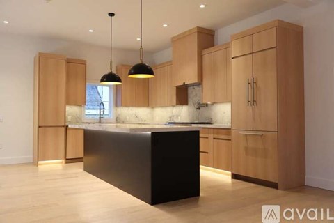 A kitchen with wooden cabinets and a black island.