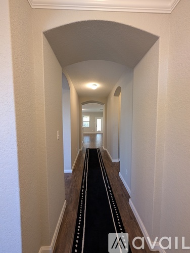A hallway with a black line down the middle and white walls.